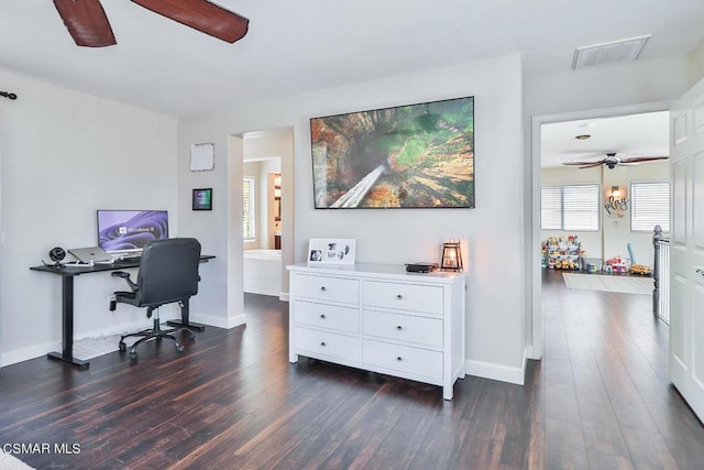 home office with dark wood-type flooring, a wealth of natural light, and ceiling fan