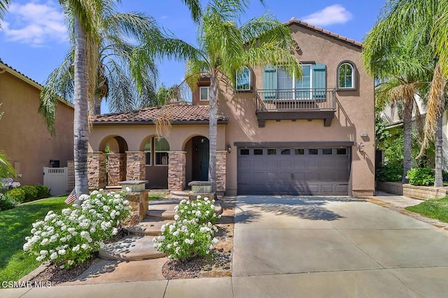 mediterranean / spanish-style home with a garage and a balcony