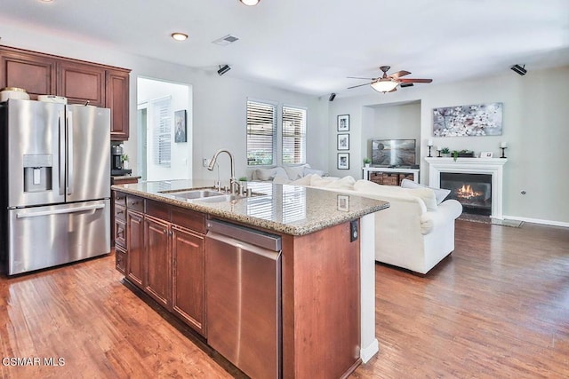 kitchen featuring sink, a center island with sink, dark hardwood / wood-style flooring, ceiling fan, and stainless steel appliances