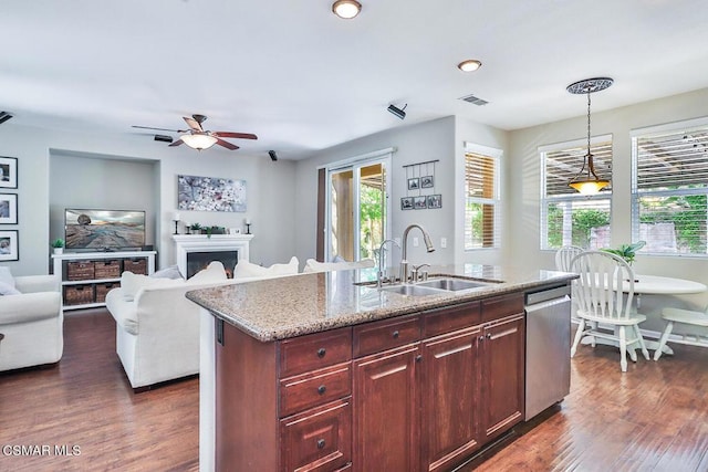 kitchen with sink, dishwasher, light stone counters, a center island with sink, and decorative light fixtures