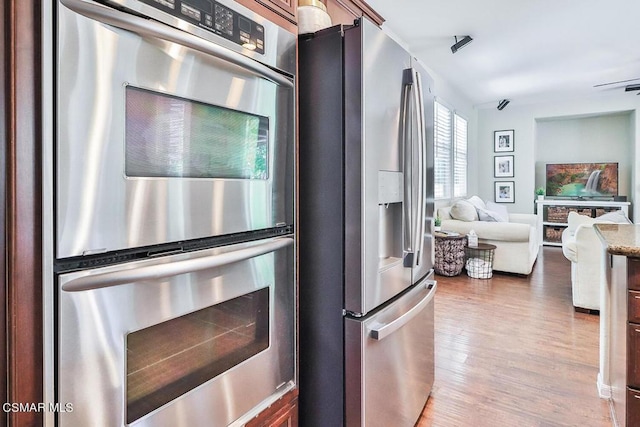 kitchen with appliances with stainless steel finishes and hardwood / wood-style floors