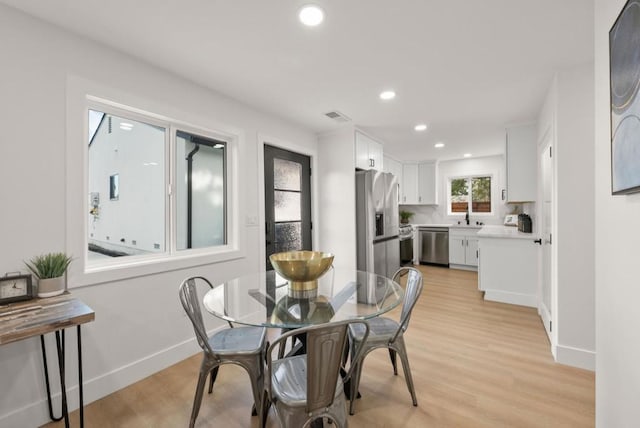 dining area featuring sink and light wood-type flooring