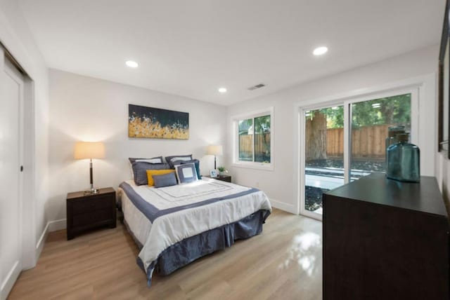 bedroom featuring access to outside, light hardwood / wood-style floors, and a closet