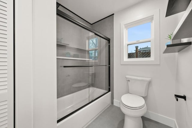 bathroom featuring toilet and shower / bath combination with glass door