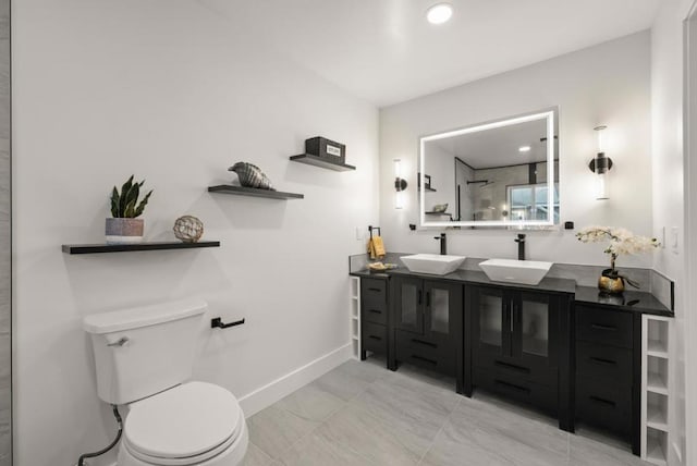 bathroom with vanity, toilet, and a tile shower