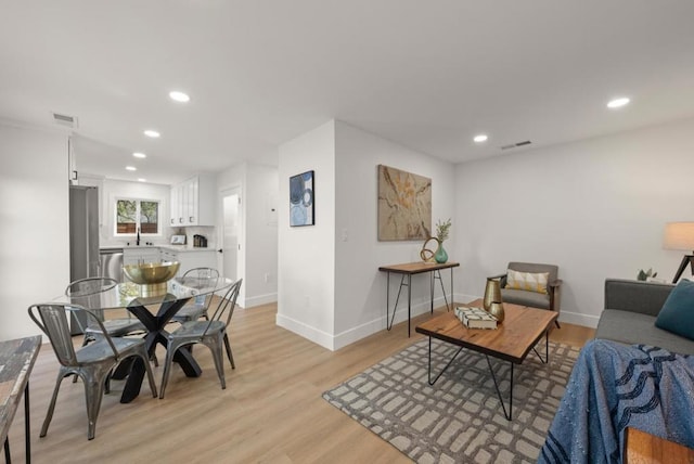 dining area with sink and light wood-type flooring