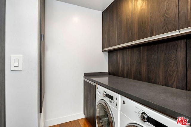 laundry room with cabinets, light hardwood / wood-style floors, and washer and dryer