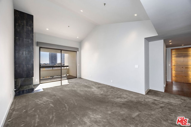 unfurnished living room with vaulted ceiling and carpet