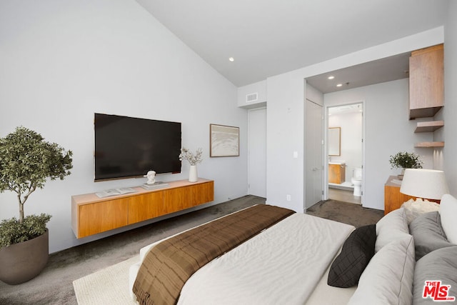 carpeted bedroom featuring lofted ceiling and connected bathroom