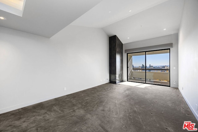 unfurnished room featuring carpet flooring and vaulted ceiling