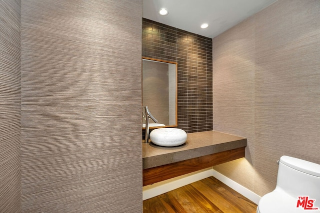 bathroom featuring wood-type flooring and toilet