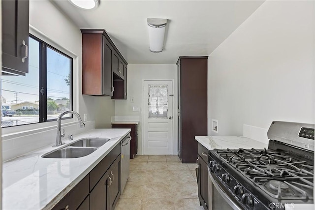 kitchen with sink, light tile patterned floors, stainless steel appliances, and light stone countertops