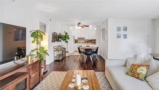 living room with dark hardwood / wood-style floors and ceiling fan