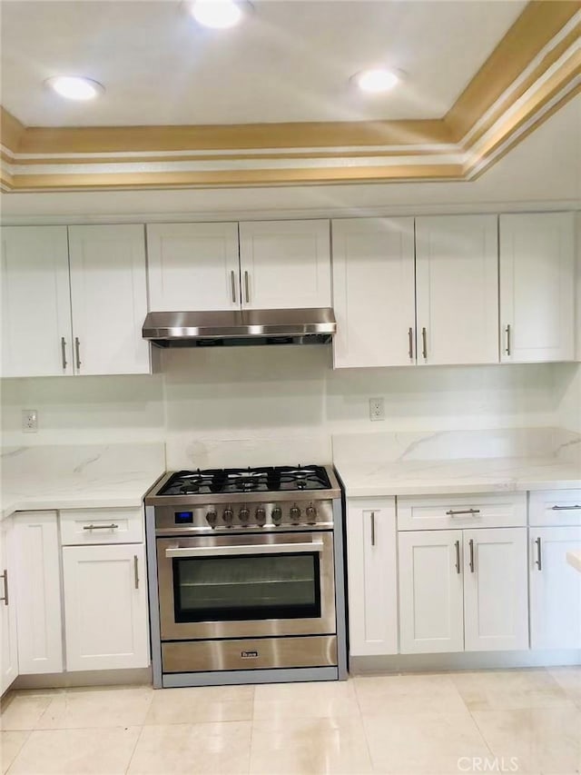 kitchen with stainless steel range with gas cooktop, white cabinetry, light tile patterned flooring, and light stone counters