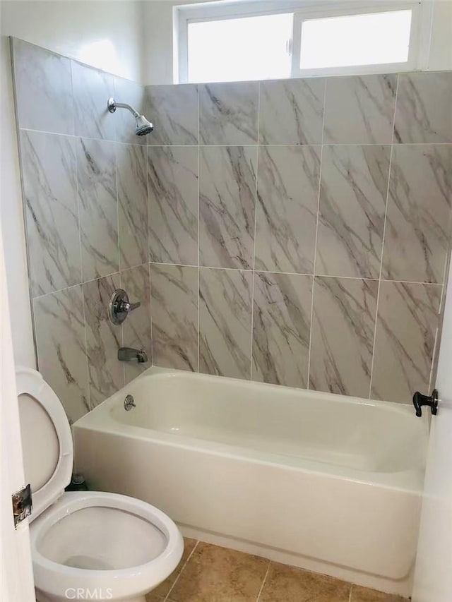 bathroom with toilet, tile patterned flooring, and tiled shower / bath combo