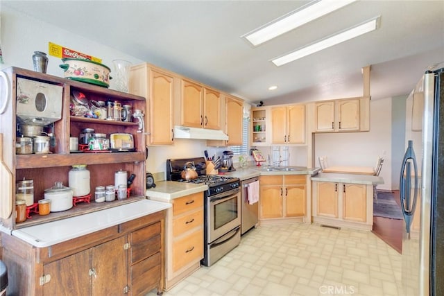 kitchen with lofted ceiling, appliances with stainless steel finishes, and light brown cabinetry