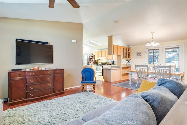 living room with hardwood / wood-style flooring, vaulted ceiling, and ceiling fan with notable chandelier