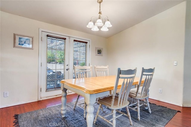 dining space featuring dark hardwood / wood-style flooring, french doors, and a chandelier