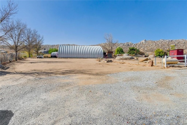 view of yard with a mountain view and an outbuilding