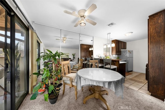 tiled dining area with ceiling fan and a wealth of natural light