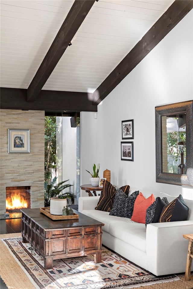 living room with hardwood / wood-style flooring, a large fireplace, and lofted ceiling with beams