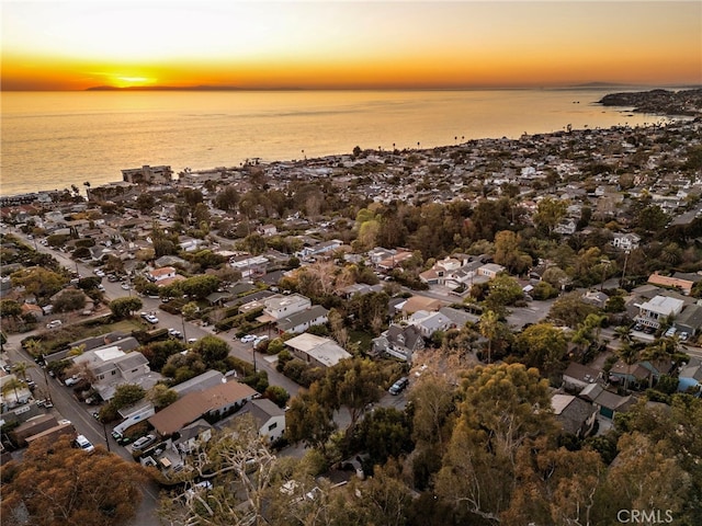 aerial view at dusk featuring a water view