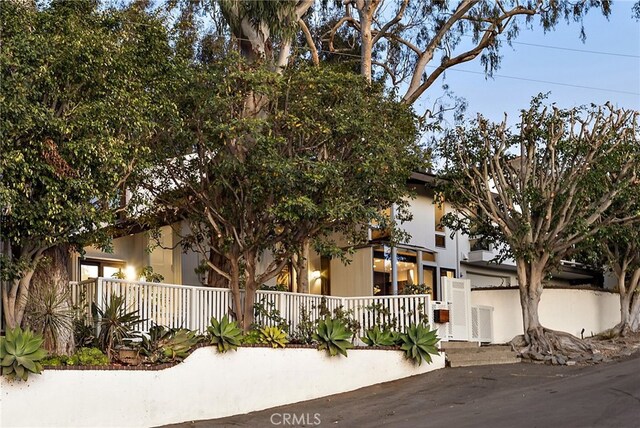 view of property hidden behind natural elements with central AC unit