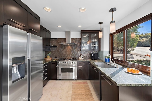 kitchen with decorative light fixtures, sink, decorative backsplash, stainless steel appliances, and wall chimney exhaust hood