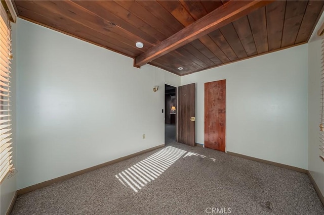 carpeted empty room with beam ceiling, wood ceiling, and baseboards