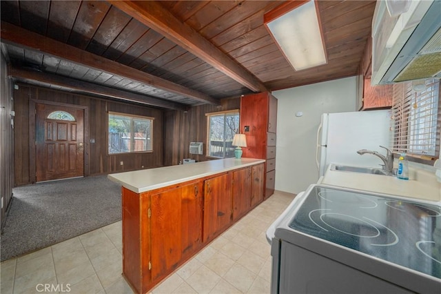 kitchen featuring sink, electric range oven, wooden walls, kitchen peninsula, and beam ceiling