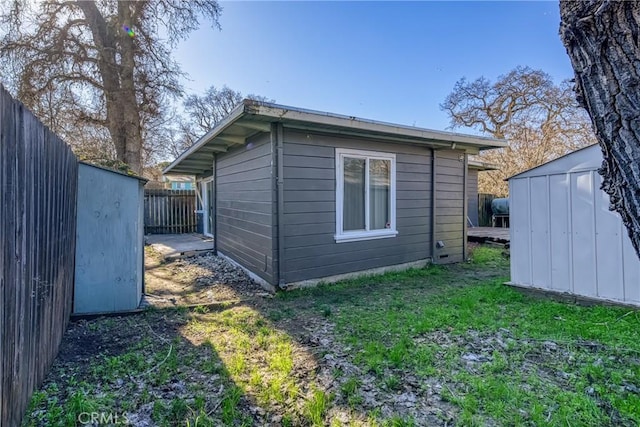 view of side of home featuring a yard and a shed