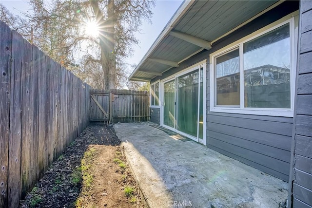 exterior space featuring a gate, a fenced backyard, and a patio