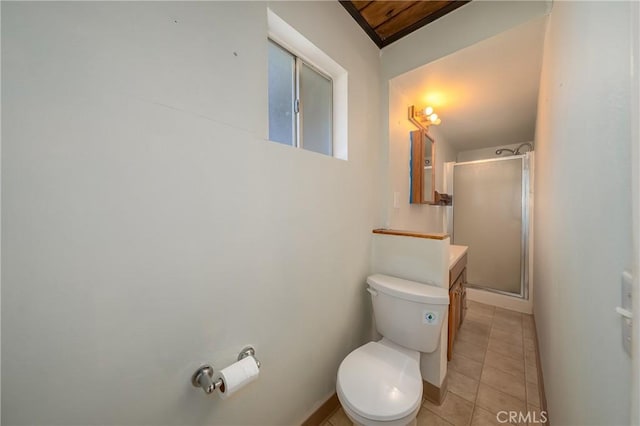 bathroom featuring a stall shower, baseboards, toilet, tile patterned floors, and vanity