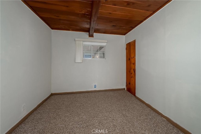 spare room featuring beamed ceiling, carpet, and wooden ceiling