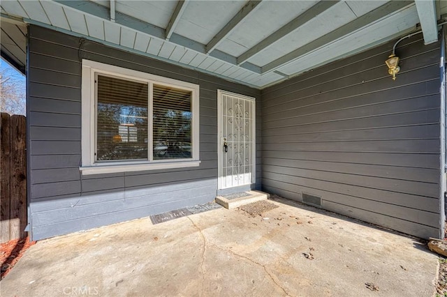 doorway to property featuring crawl space, a patio area, and fence