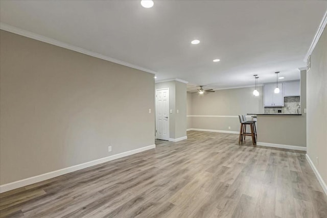 unfurnished living room with crown molding, light hardwood / wood-style floors, and ceiling fan