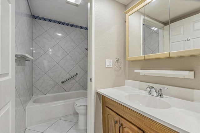 full bathroom featuring vanity, tiled shower / bath, tile patterned flooring, and toilet