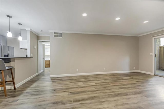 unfurnished living room featuring hardwood / wood-style flooring and crown molding