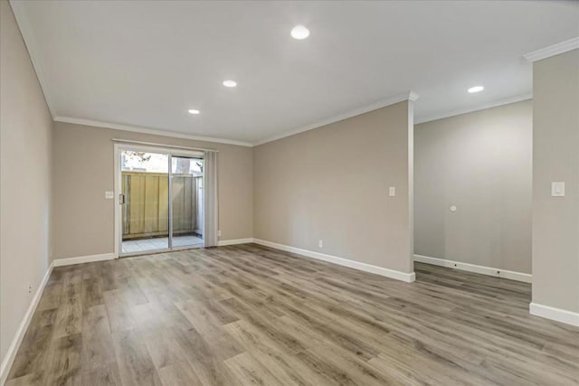 spare room with ornamental molding and light hardwood / wood-style floors