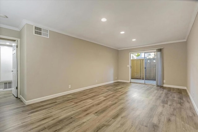 spare room featuring crown molding and light hardwood / wood-style flooring