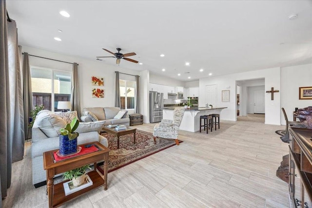 living room with ceiling fan and light wood-type flooring