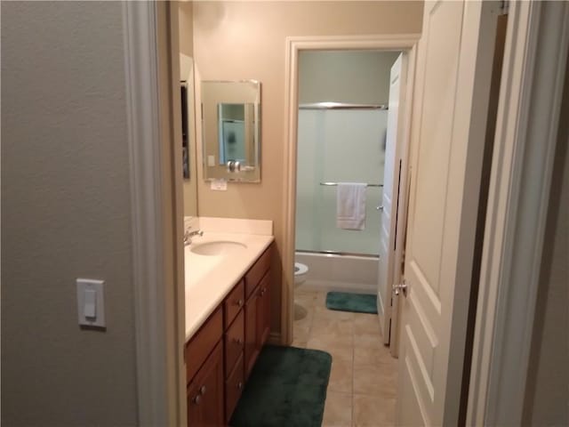 full bathroom with vanity, tile patterned floors, shower / bath combination with glass door, and toilet