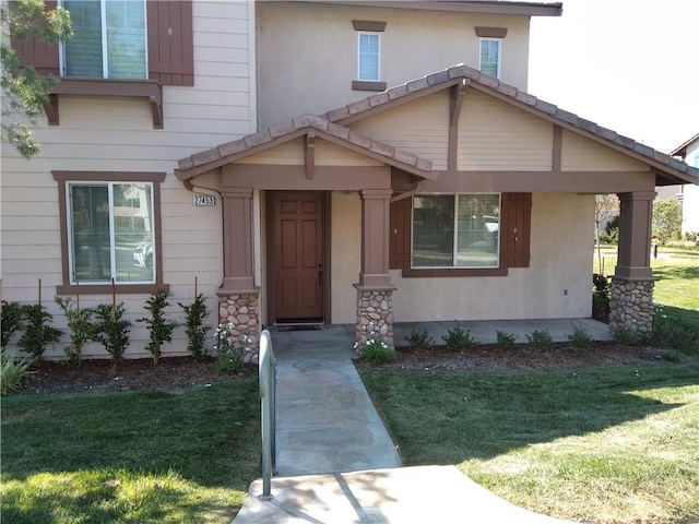 property entrance with a lawn