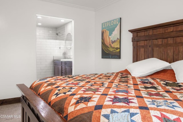 carpeted bedroom featuring ornamental molding and ensuite bathroom