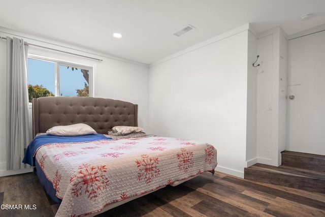 bedroom featuring ornamental molding and dark hardwood / wood-style floors