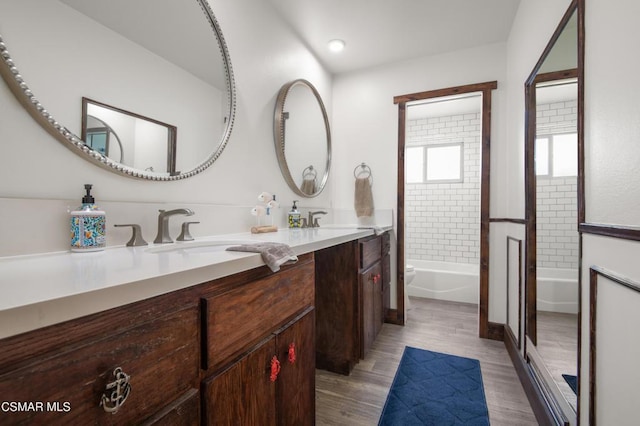 full bathroom featuring vanity, toilet, tiled shower / bath combo, and wood-type flooring