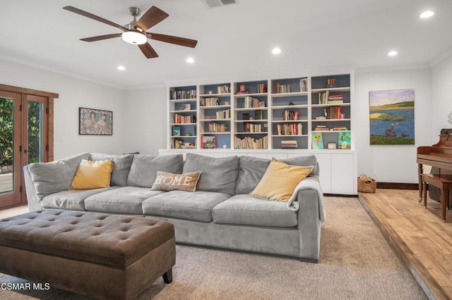 living room with crown molding, ceiling fan, and light wood-type flooring