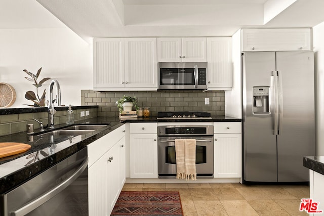 kitchen with stainless steel appliances, white cabinetry, tasteful backsplash, and sink