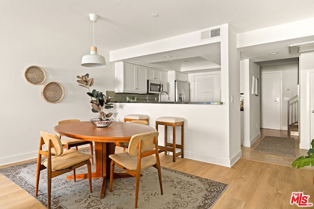 dining area with sink and light hardwood / wood-style flooring