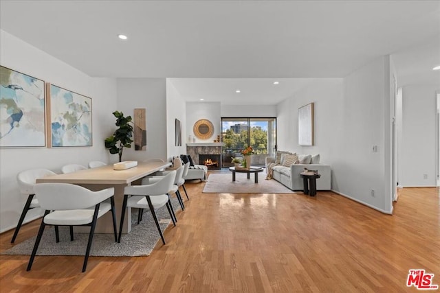 dining room with a fireplace and light wood-type flooring